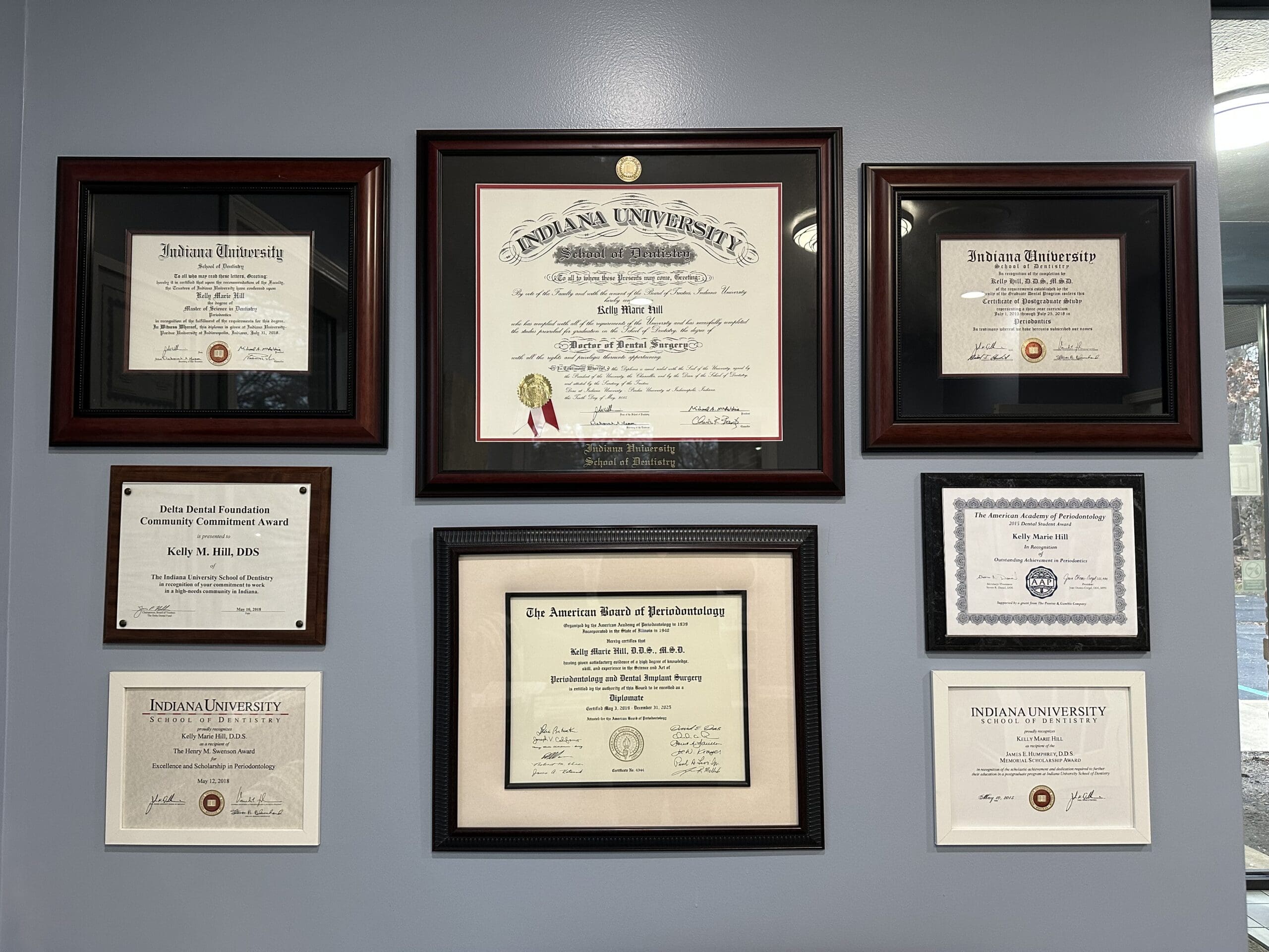 Framed diplomas and board certification awards displayed at Elkhart Periodontics, showcasing Dr. Kelly Hill’s advanced training in periodontology and laser dentistry.